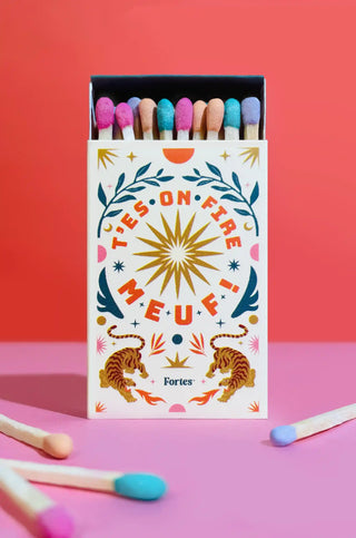 Petite boîte d’allumettes multicolores Fortes ouverte, avec message « T’es on fire meuf » et tigres illustrés